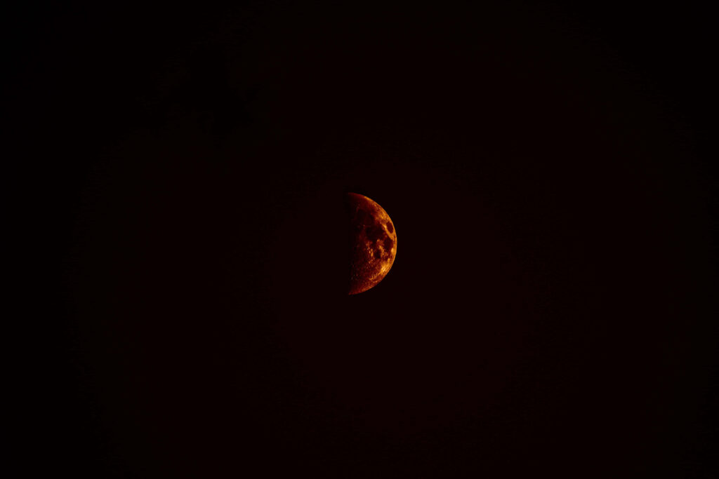 Ethereal Red Moon Wallpaper on Black Background - Dramatic Atmosphere