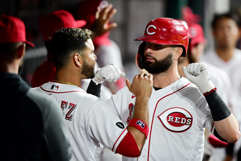 Eugenio Suárez celebrates confidently with Cincinnati Reds teammate in vibrant dugout scene Wallpaper