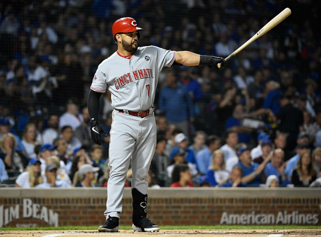 Eugenio Suárez Cincinnati Reds at bat focused ready to swing in vibrant stadium background Wallpaper