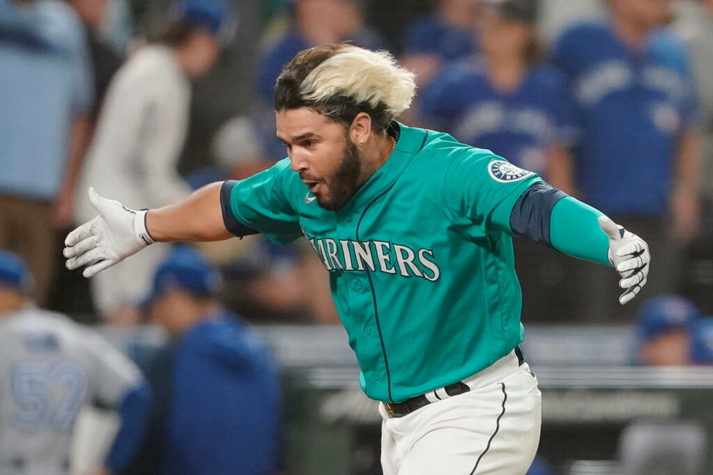 Eugenio Suárez Mariners celebrating intense baseball moment teal jersey dynamic stadium background Wallpaper