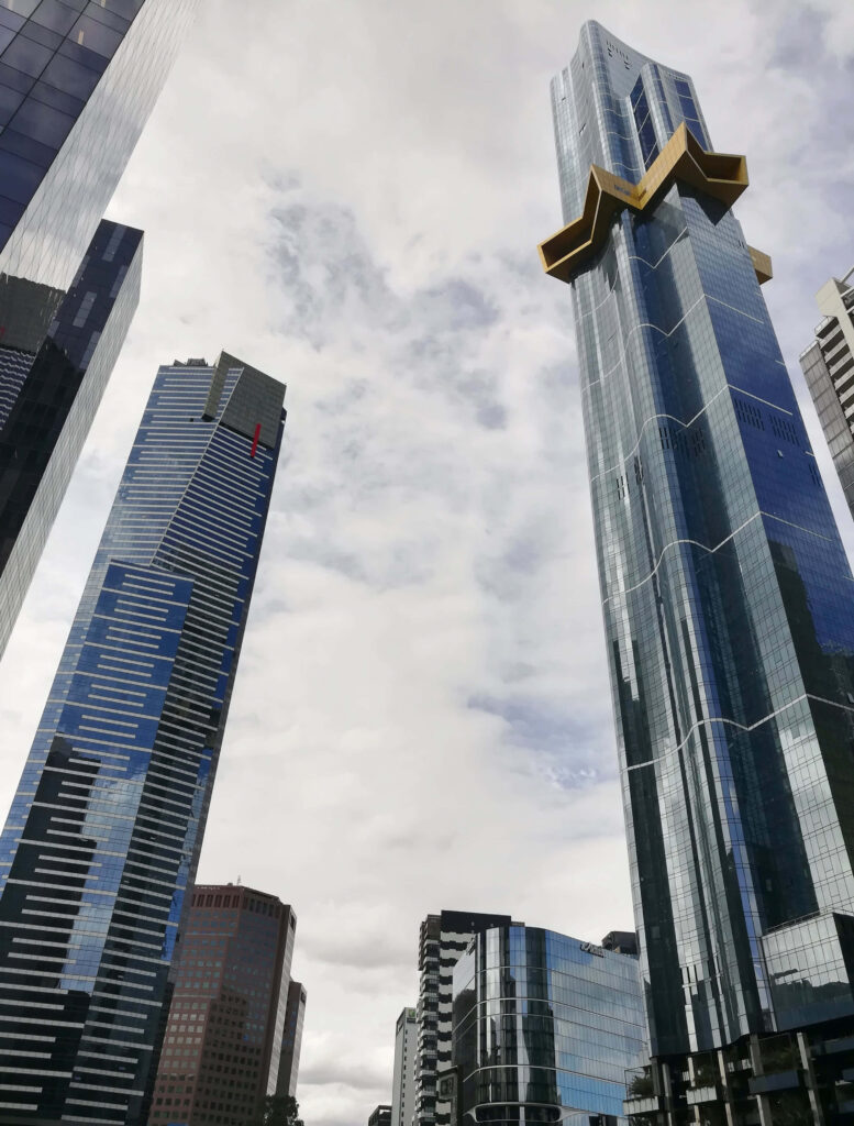 Eureka Tower Melbourne skyline with gold crown and blue glass facade under cloudy sky wallpaper