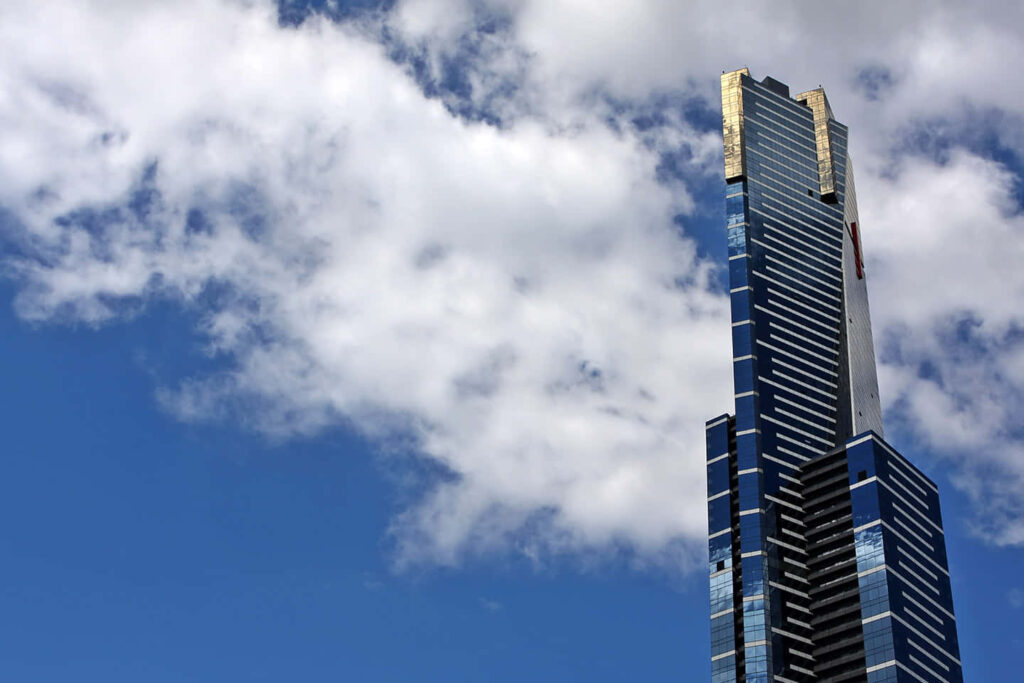 Eureka Tower Melbourne skyline wallpaper with gold accents under vivid blue sky and clouds