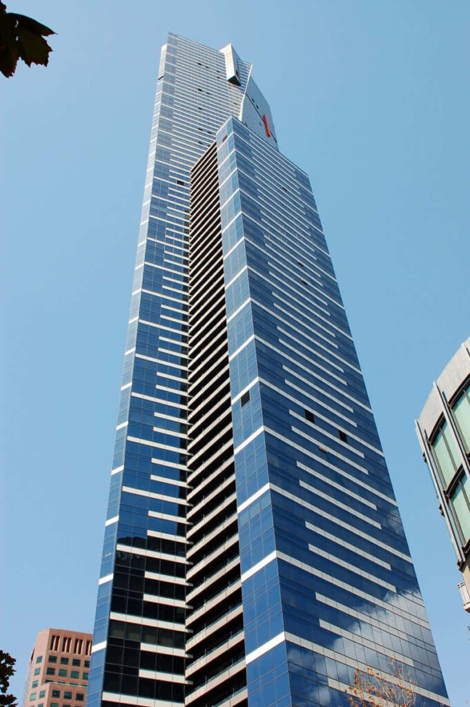 Eureka Tower Melbourne with gold accents and glass façade against clear blue sky wallpaper background
