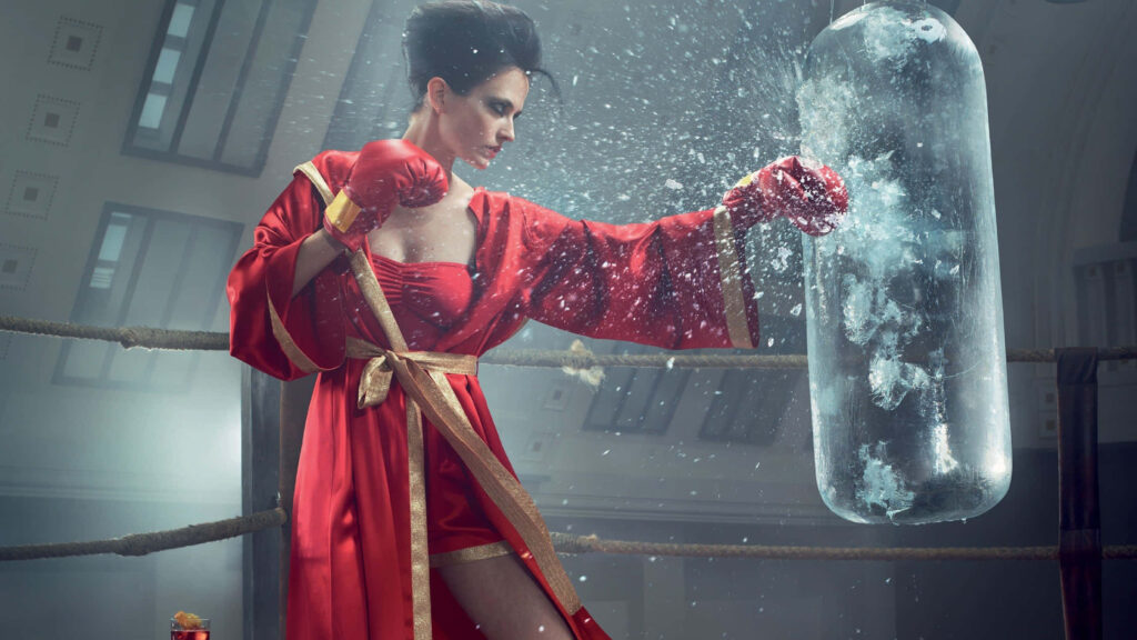Eva Green punches frozen bag in red robe inside boxing ring dramatic intense action wallpaper