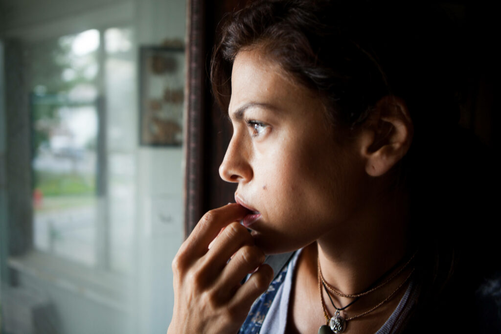 Close up of Eva Mendes gazing thoughtfully out window showcasing natural beauty and expression Wallpaper