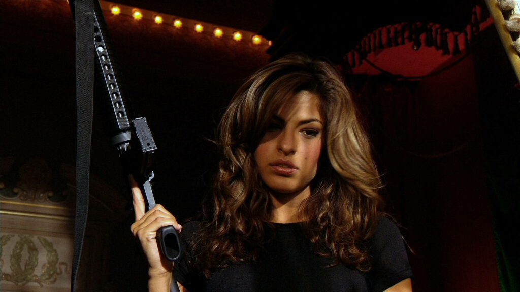Eva Mendes holding firearm in dramatic moody lighting dark atmospheric wallpaper background