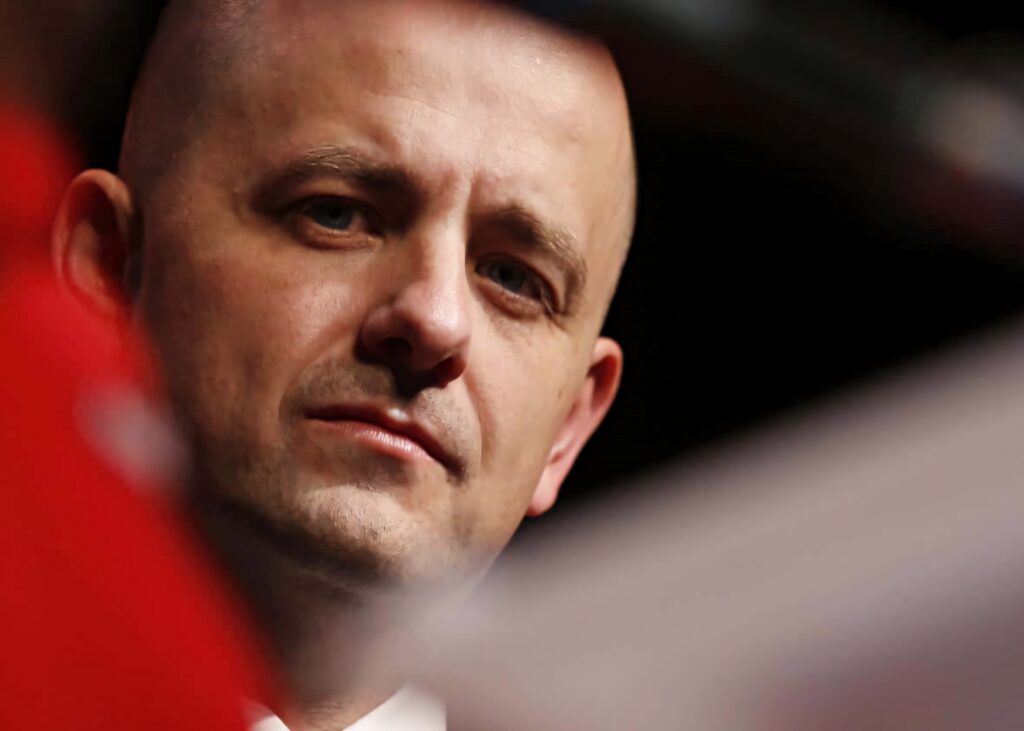 Close-up portrait of Evan McMullin with thoughtful expression soft warm lighting blurred background Wallpaper