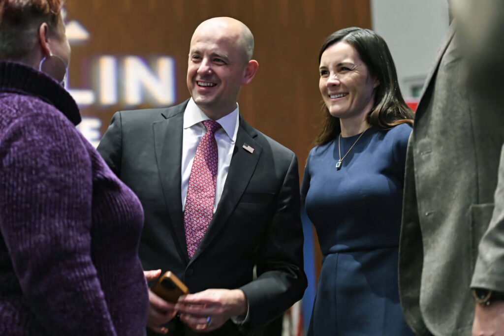 Evan McMullin Utah Senate candidate smiling with wife Emily in formal attire warm background Wallpaper