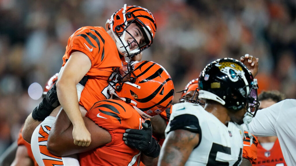 Evan McPherson Bengals celebration wallpaper vibrant orange black team unity football stadium background