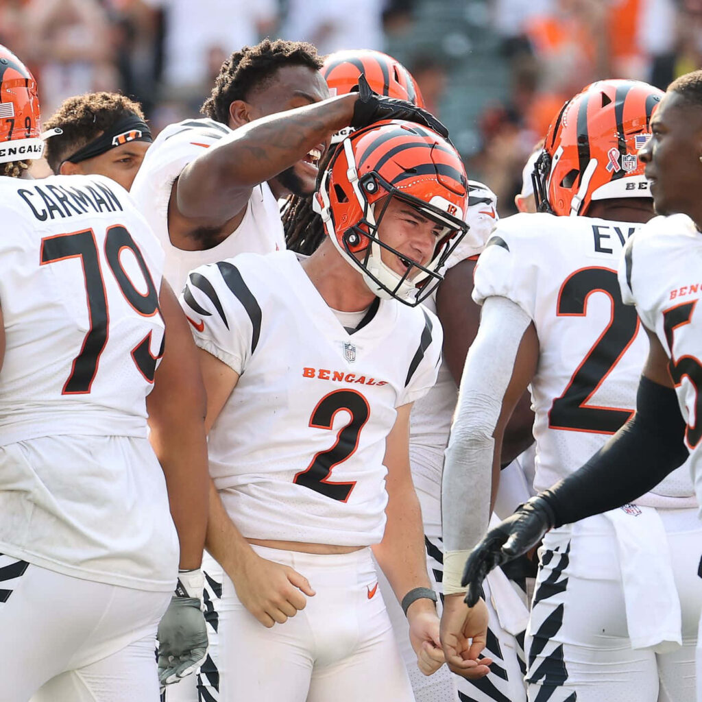 Evan McPherson in white Bengals uniform with teammates celebrating on field vibrant orange black Wallpaper