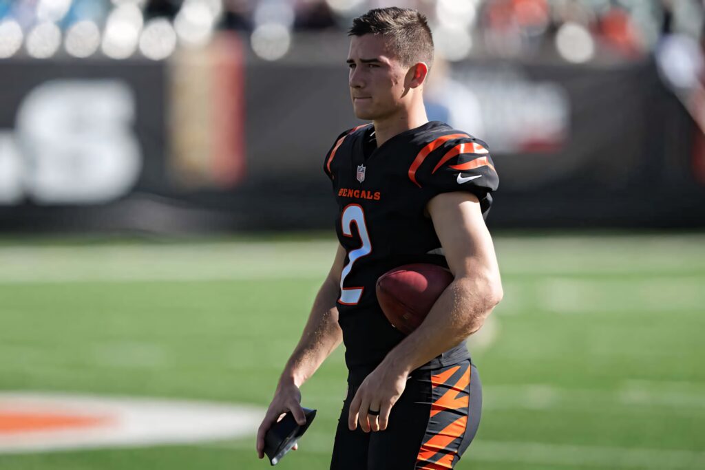 Evan McPherson in Cincinnati Bengals uniform holding football on field bright game day light Wallpaper