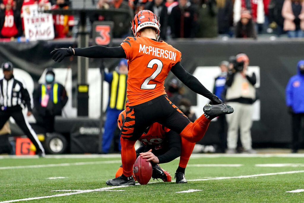 Evan McPherson Cincinnati Bengals kicker in orange black uniform preparing field goal stadium background Wallpaper