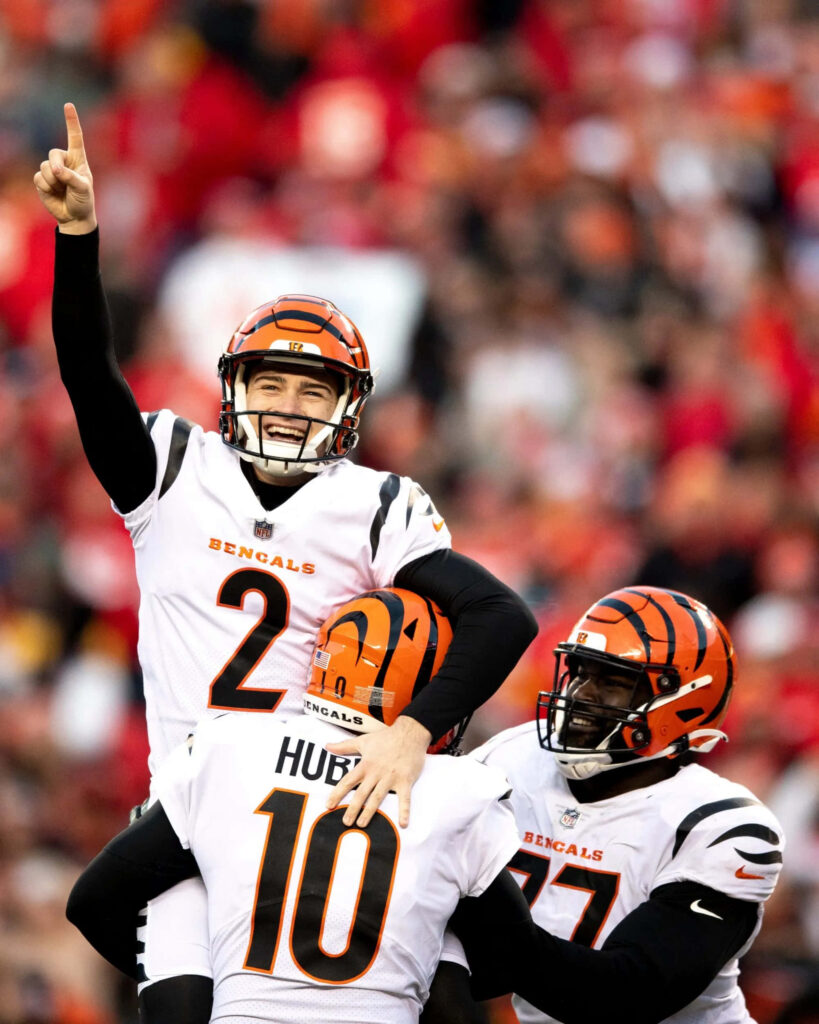 Evan McPherson and Cincinnati Bengals celebrate victory in white orange uniforms on football field Wallpaper
