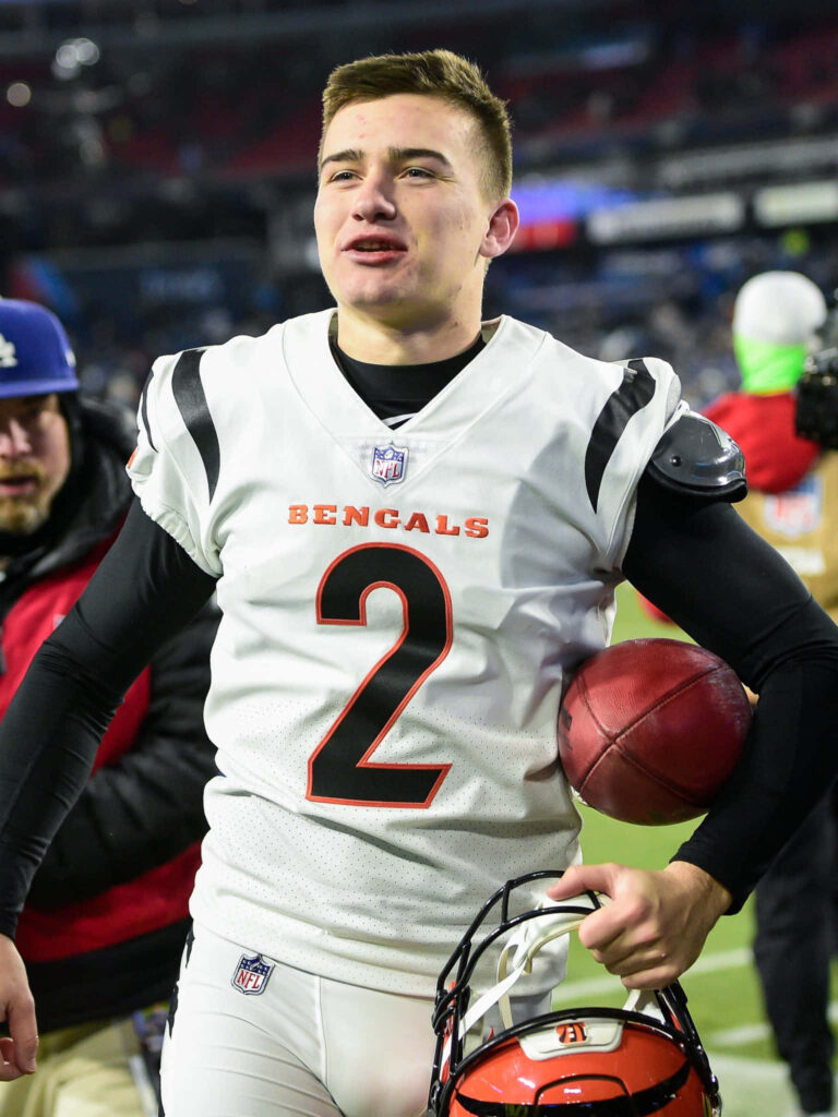 Evan McPherson Cincinnati Bengals kicker in white uniform holding football on stadium field wallpaper