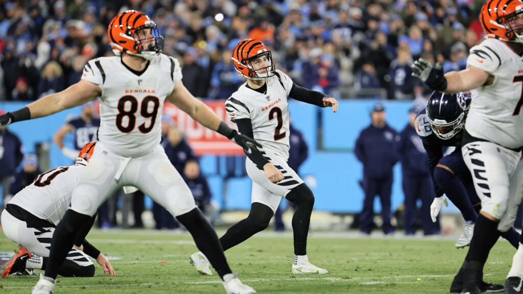 Evan McPherson kicking for Cincinnati Bengals in white orange uniform on vibrant football field Wallpaper