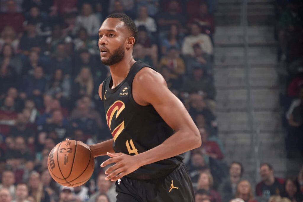 Evan Mobley in black Cleveland Cavaliers jersey dominating court with dynamic action lighting Wallpaper