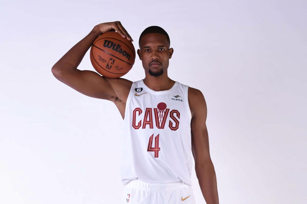 Evan Mobley in Cleveland Cavaliers uniform holding basketball on shoulder with focused expression Wallpaper