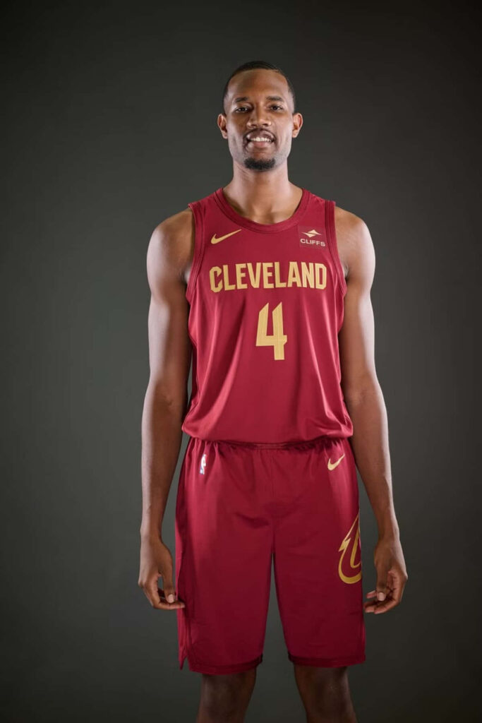 Evan Mobley in Cleveland Cavaliers uniform showcasing athletic build on dark basketball wallpaper