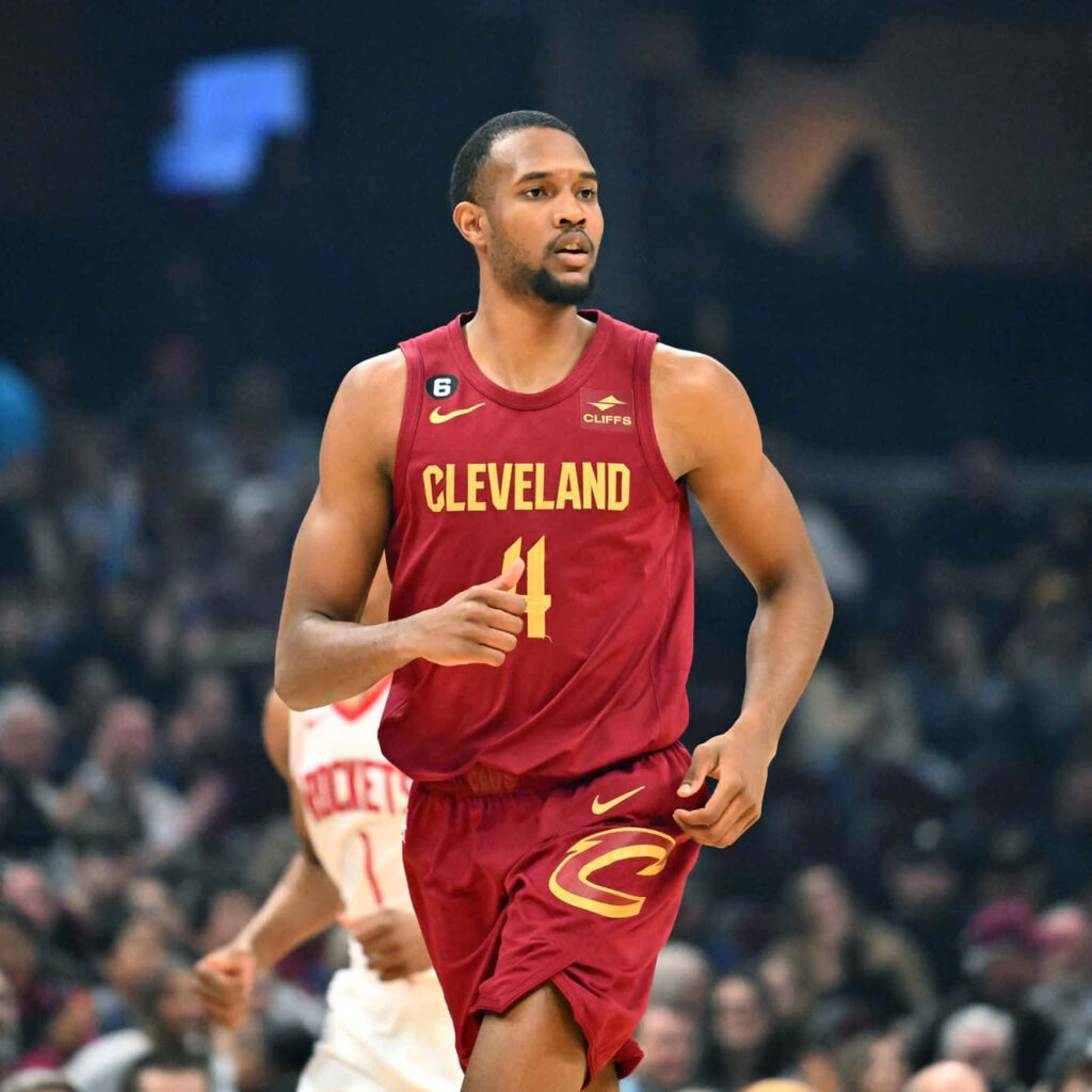 Evan Mobley in Cleveland Cavaliers uniform mid-motion on court dynamic NBA game wallpaper background