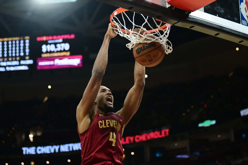 Evan Mobley dunking powerfully for Cleveland Cavaliers in vivid arena with intense basketball action Wallpaper