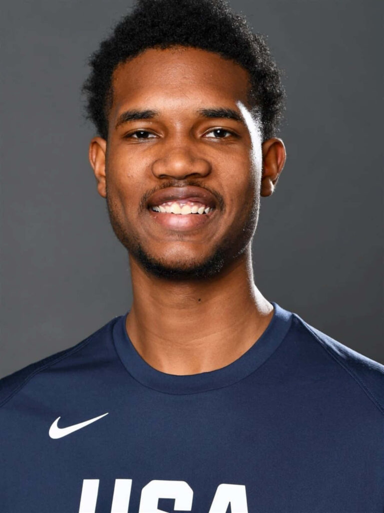 Evan Mobley high-resolution portrait in navy USA shirt smiling athletic confident gray background Wallpaper
