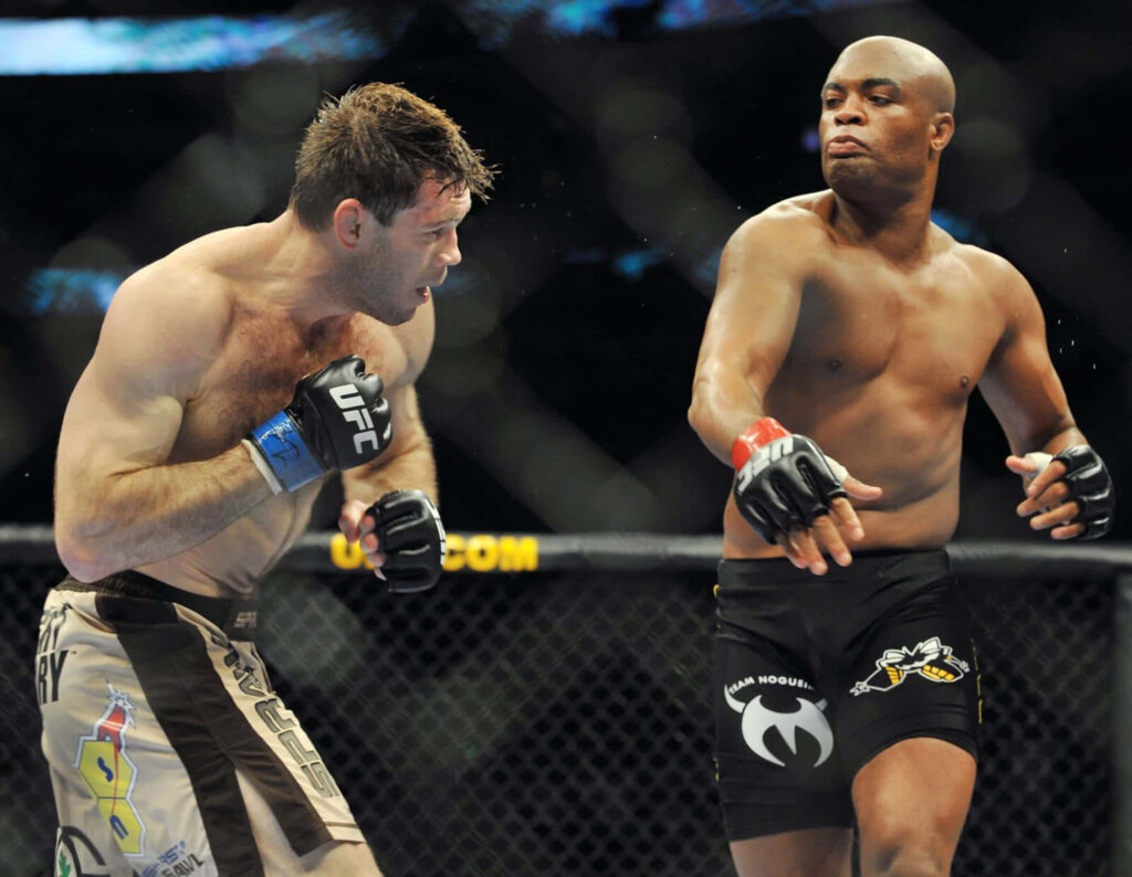 MMA fighters Evan Tanner and Anderson Silva intense UFC octagon face-off dynamic wallpaper background