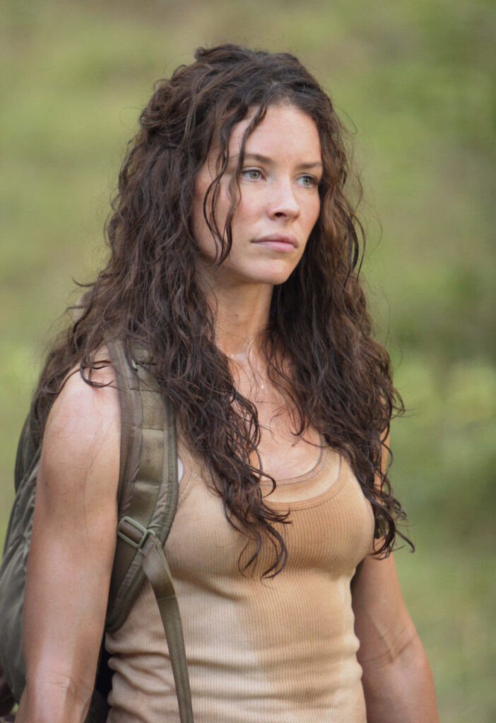 Evangeline Lilly outdoors with curly hair tan tank top backpack natural green background soft light Wallpaper