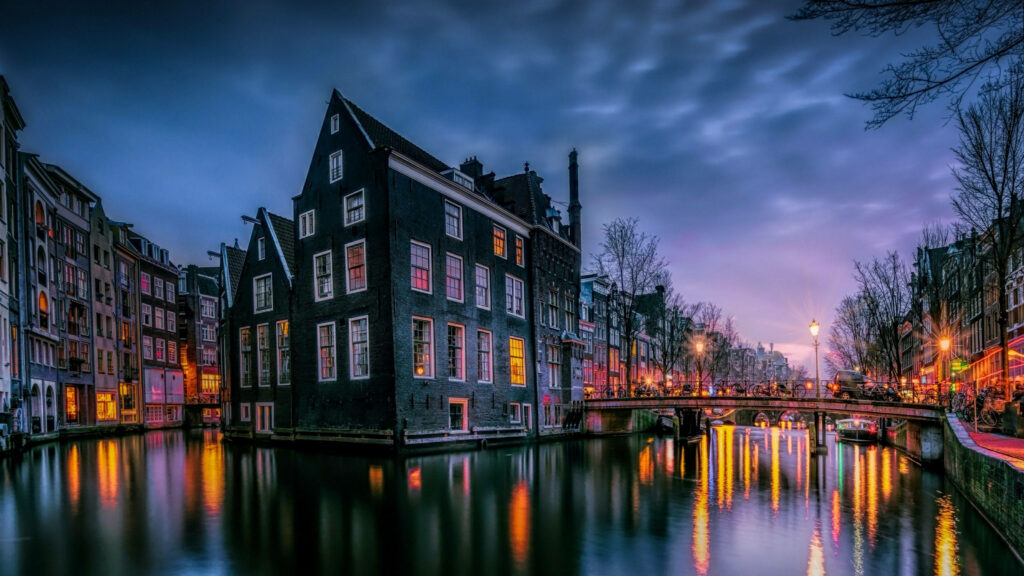 Evening Amsterdam Canal: Historic Buildings & Colorful Reflections Wallpaper