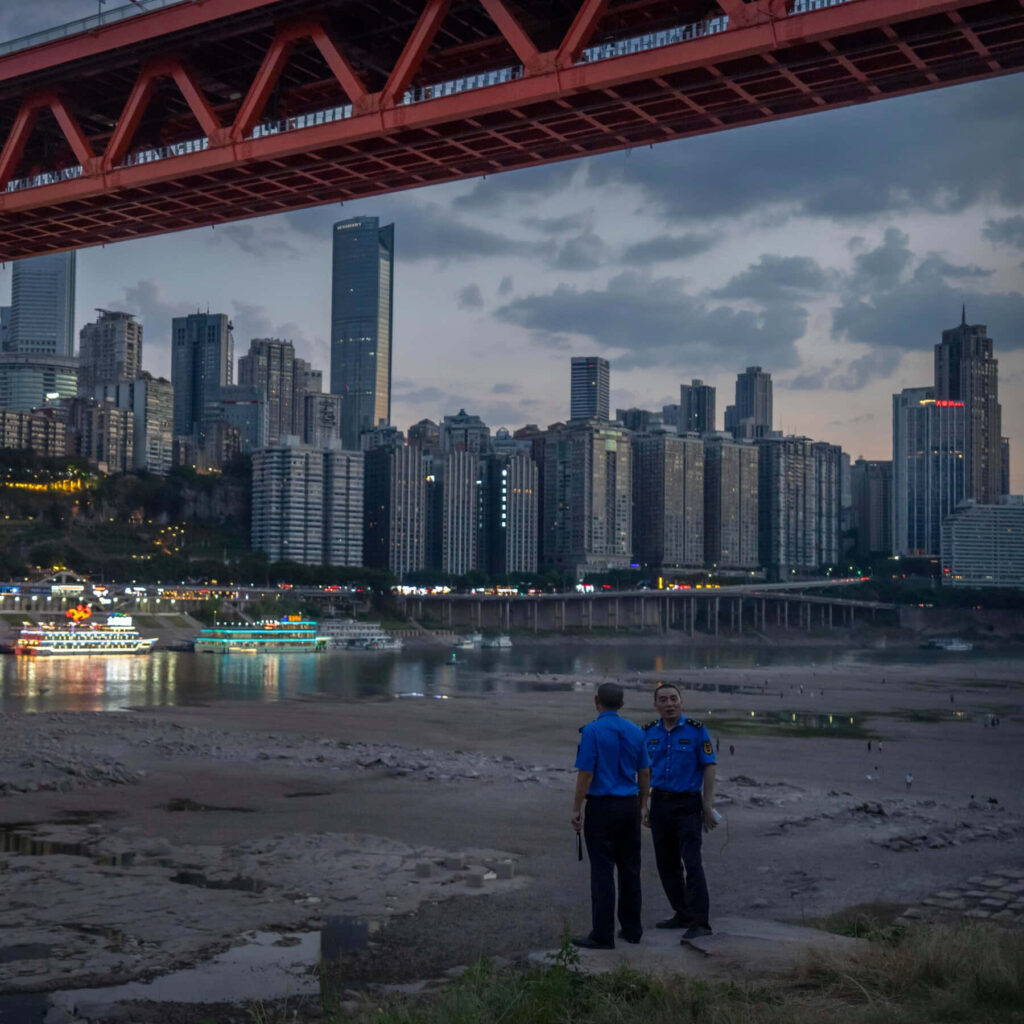 Evening Cityscape: Police Officers Under Red Bridge in China Wallpaper