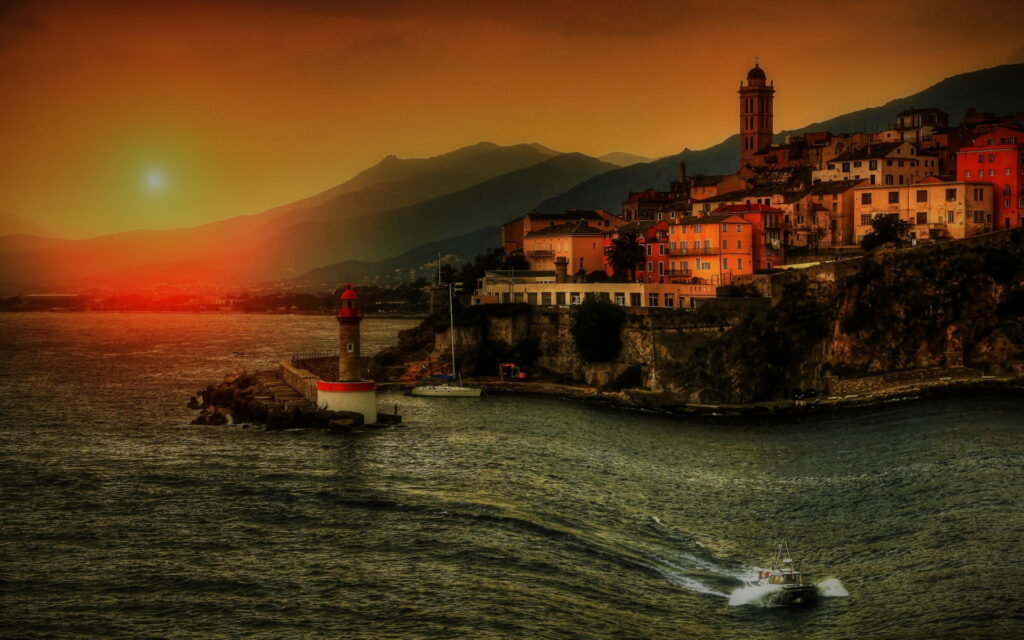 Golden Hour Serenade: Majestic Mediterranean Sunsets by an Italian Coastal Lighthouse Wallpaper