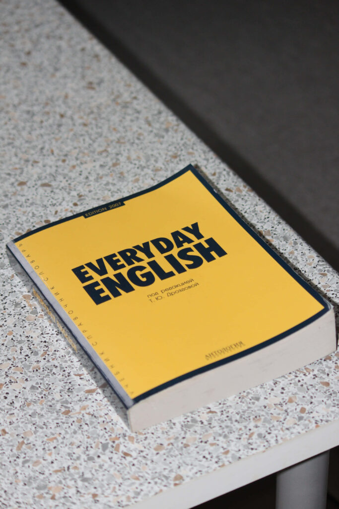 Bright yellow Everyday English book on speckled countertop highlighting practical language learning Wallpaper