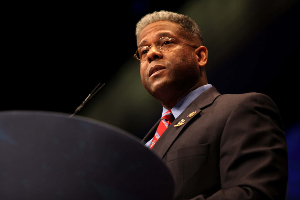 Ex Army Allen West delivering a speech in suit and tie with determined expression at podium Wallpaper