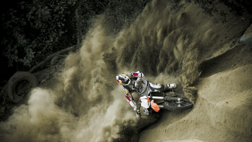Thrilling Dirt Bike Rider in Sandy Dunes - Exciting Wallpaper Background