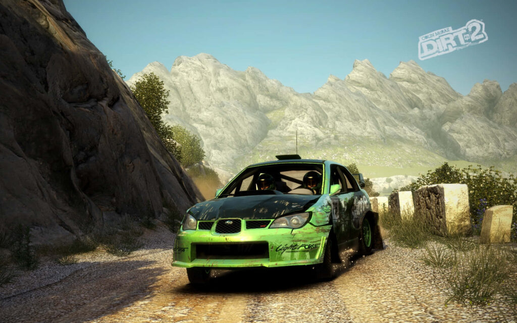 Dirt's Thrilling Ride: Green Speedster Conquering Mountainous Terrain on Twisty Road Wallpaper