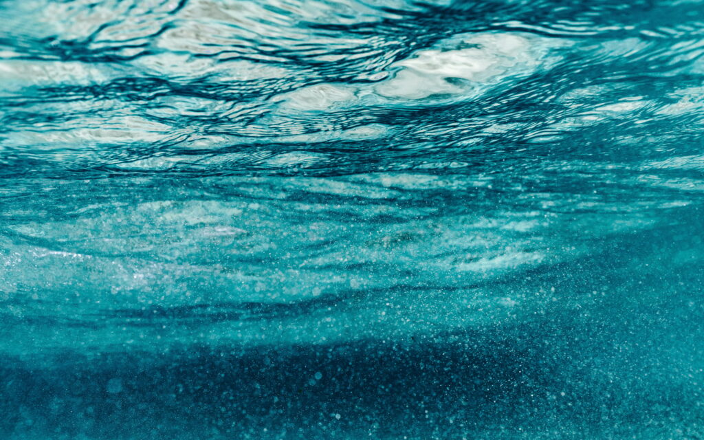 Macro underwater photo with blue textures light refraction bubbles calming cyan waves wallpaper