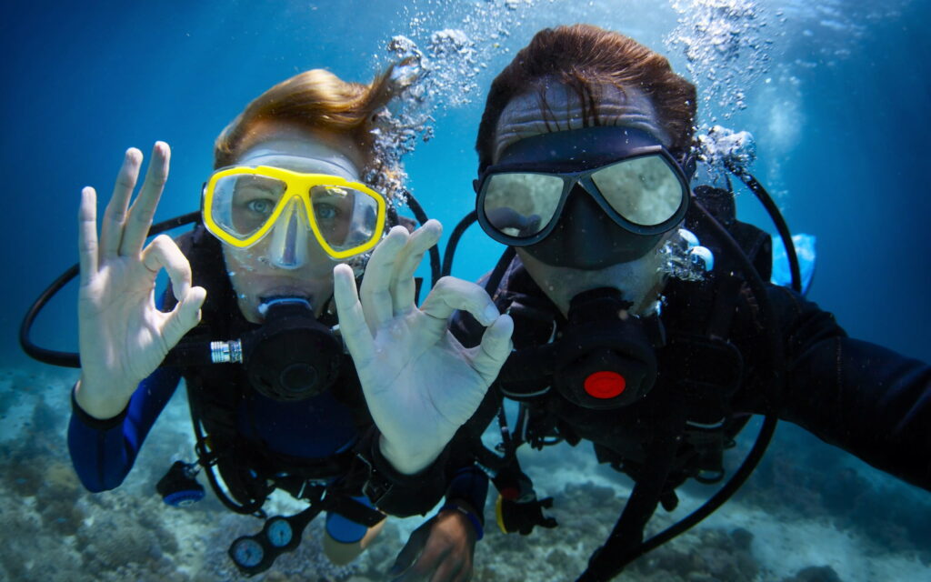 Exploring the Depths: Captivating QHD Wallpaper of Underwater Divers Embracing Diving Concepts