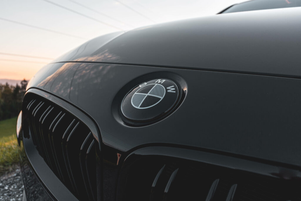 Showcasing the Elegant Black BMW M Series Car with Iconic Logo in the Background Wallpaper
