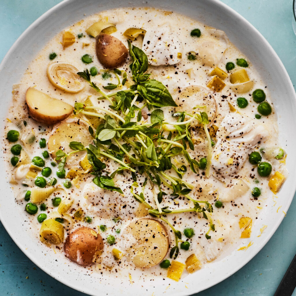 Vibrant fish chowder wallpaper with creamy broth potato slices green peas and fresh herbs