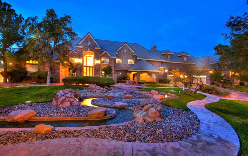 The Majestic Villa: A Captivating Snapshot of Luxury Homes Nestled Amongst Scenic Rocks and Lush Lawns Wallpaper