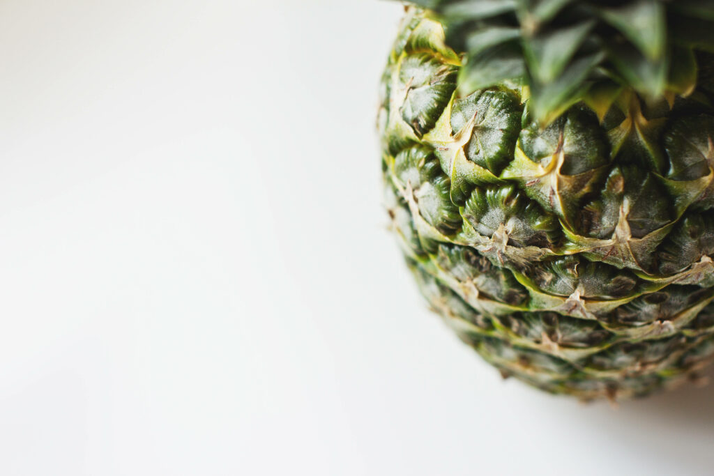 Pineapple Bliss: A Captivating Close-Up of Nature's Artistry on a Yellow Canvas Wallpaper