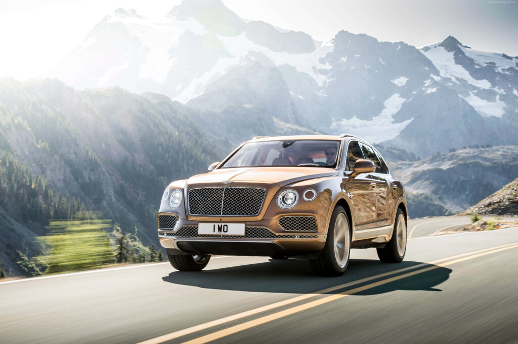Bentley Bentayga Dominates Scenic Drive amidst Lush Greenery Wallpaper