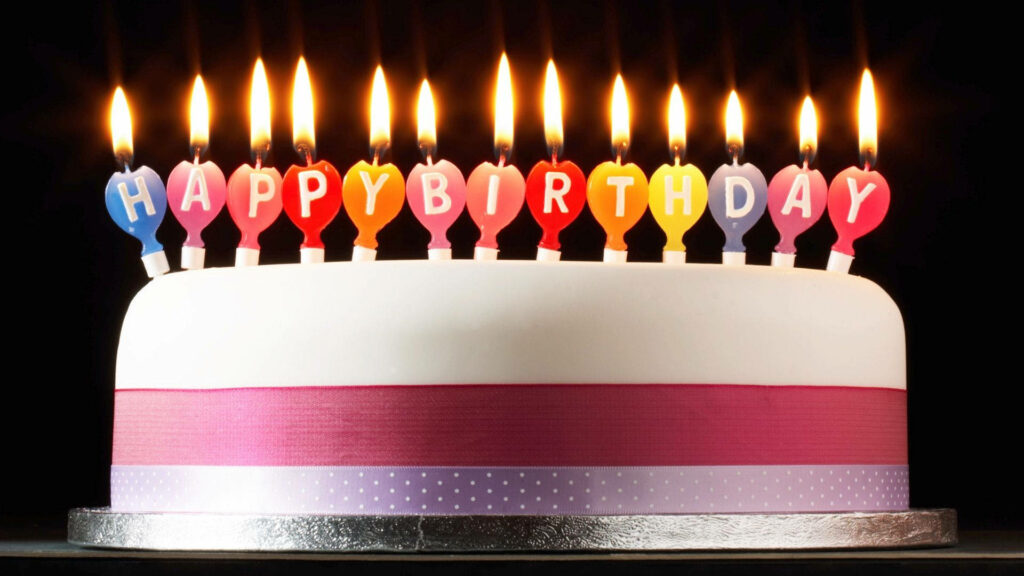 Simplicity with a Burst of Color: Vibrant Happy Birthday Candles Accentuate a Beautifully Minimalist Birthday Cake Wallpaper