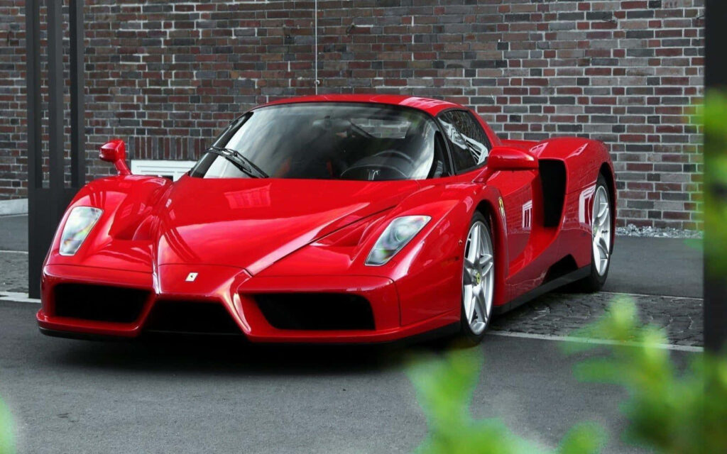 Unleashing the Raw Power: Striking High-Resolution Image of the Iconic Red Ferrari Enzo in a Majestic Outdoor Environment Wallpaper