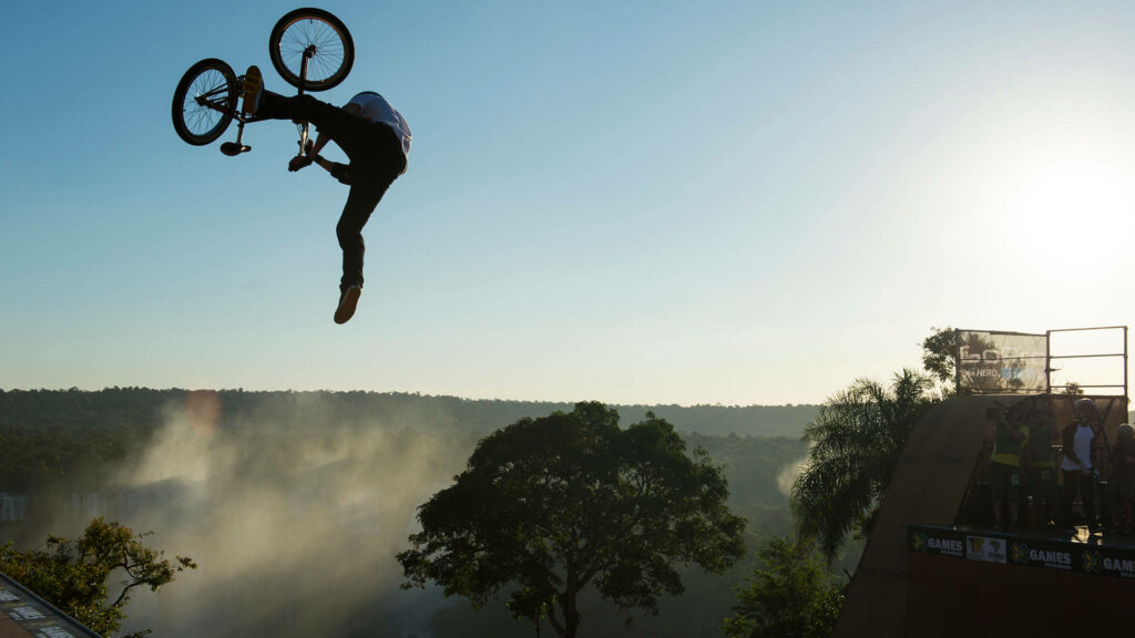 Epic Airborne Stunt: X Games Freestyler Wows Crowd with Thrilling BMX Trick Wallpaper