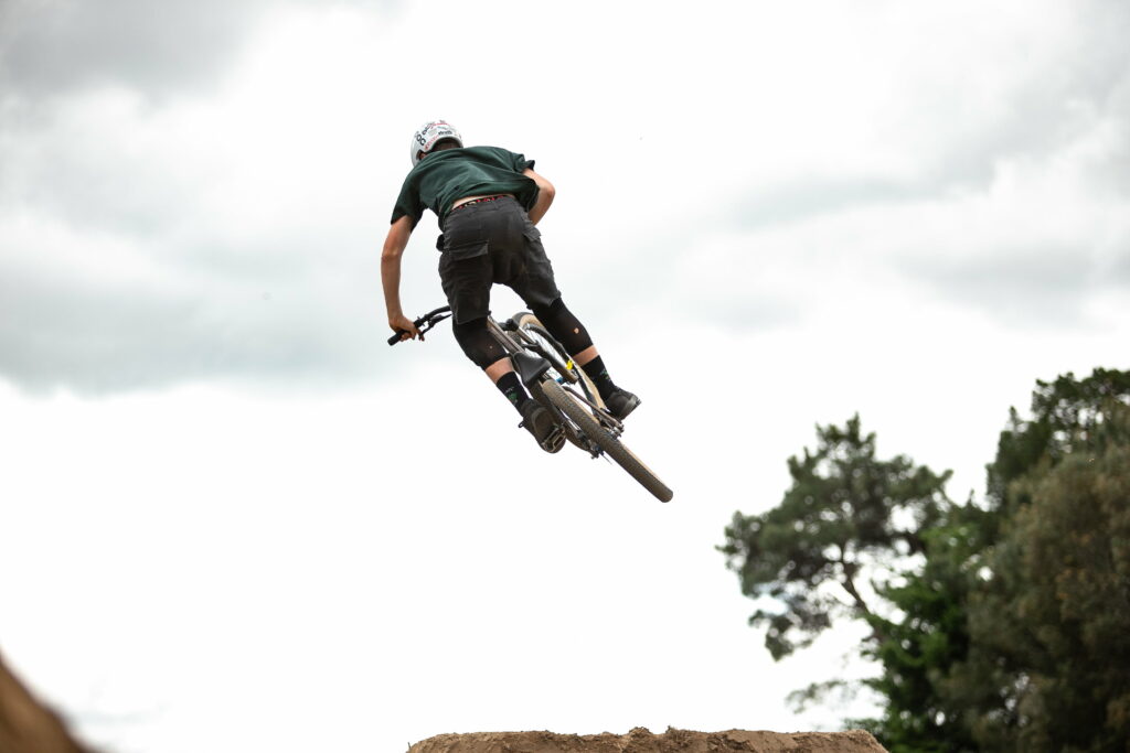 Adrenaline Rush: Mountain Biking Soars Through the Air in Epic QHD Wallpaper