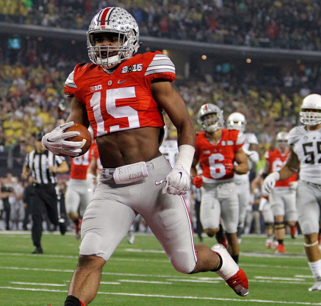 Ezekiel Elliott Ohio State football action under bright stadium lights with vibrant crowd background Wallpaper