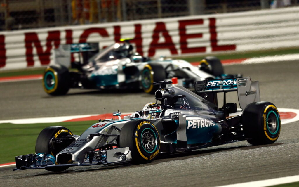 Lewis Hamilton in Mercedes AMG Petronas drives past Michael turn Bahrain GP F1 night race wallpaper