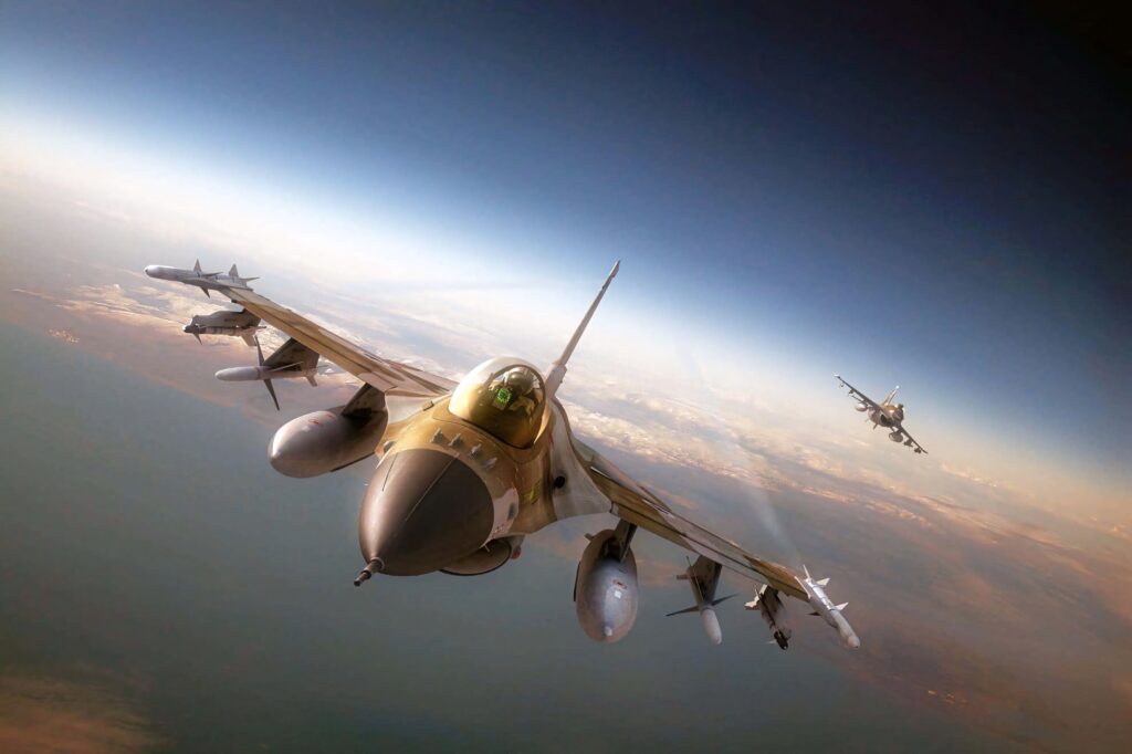 Close-up of General Dynamics F-16 Fighting Falcon in flight showing camouflaged fuselage and weapons Wallpaper