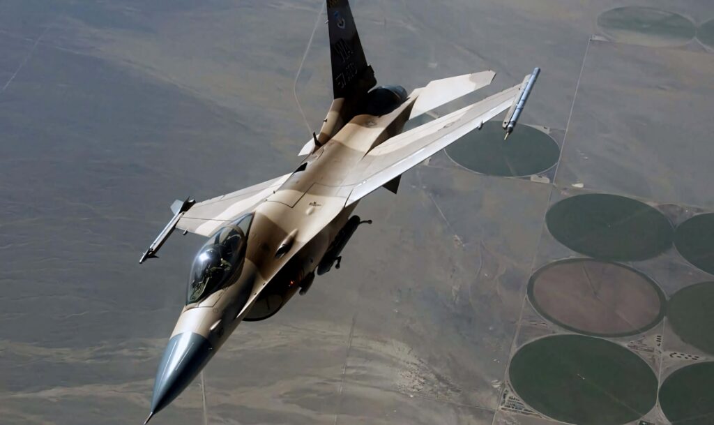General Dynamics F-16 Fighting Falcon desert camo fighter jet flying over arid landscape wallpaper