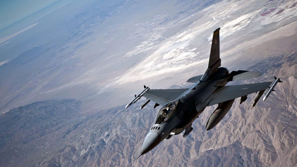 General Dynamics F-16 Fighting Falcon jet flying over rugged mountains clear sky wallpaper background